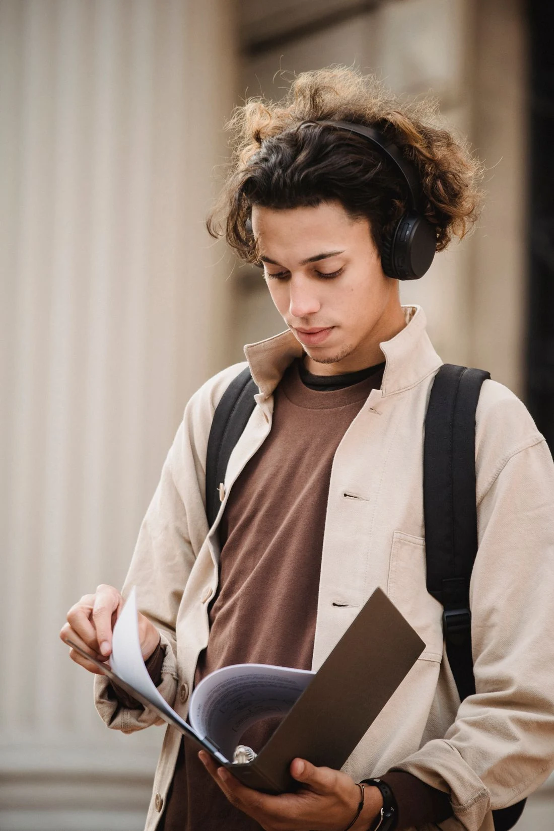 A person reading with headphones outdoors